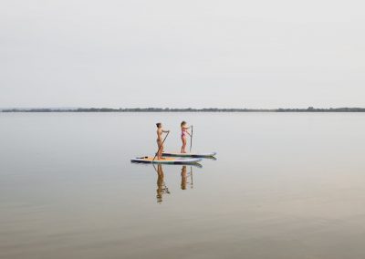 Two women paddleboarding on a calm lake