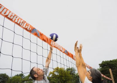 A volleyball action shot with two people on opposing teams at the net